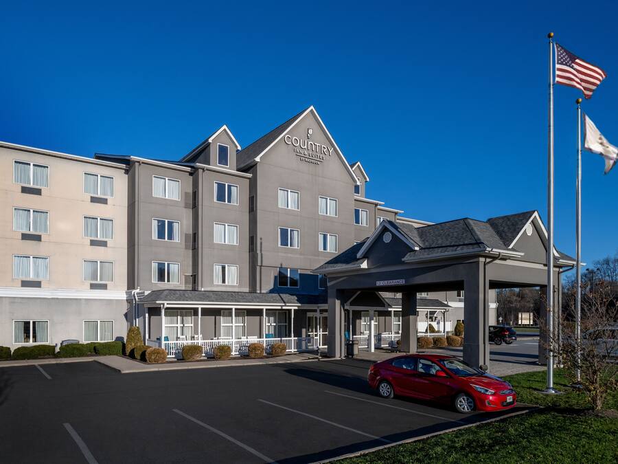 A multi-story hotel with a covered entrance and a parking lot.