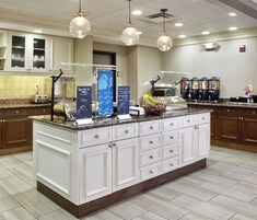 Una cocina de hotel con una isla central, una estación de café y una zona de buffet.