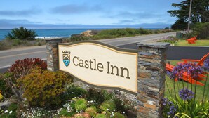 A sign for Castle Inn with a view of the ocean. - Castle Inn (Cambria)