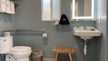 A bathroom with a toilet, sink, and wooden stool.