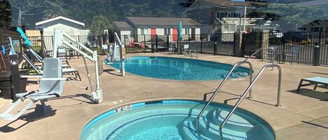 A swimming pool with a 3-foot and 6-inch depth marking, a lifeguard stand, and a small deck area with chairs and a table.