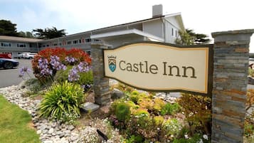 Señal del Castle Inn, con muro de piedra y jardín ajardinado.