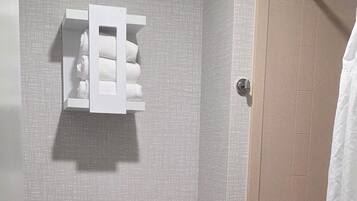 A small bathroom with a toilet, a towel rack, and a shower curtain.