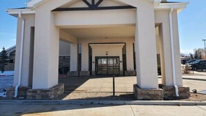 Un edificio con un acceso cubierto, columnas y una puerta marcada con el número 377.