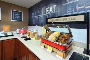 A breakfast buffet with various food options and a sign indicating the start of breakfast. - Hampton Inn & Suites Tucson East/Williams Center (Tucson)