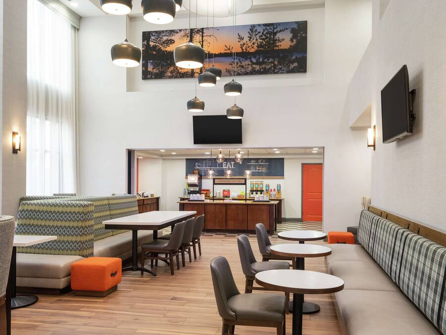 A modern interior with seating areas, a bar, and a large painting on the wall.