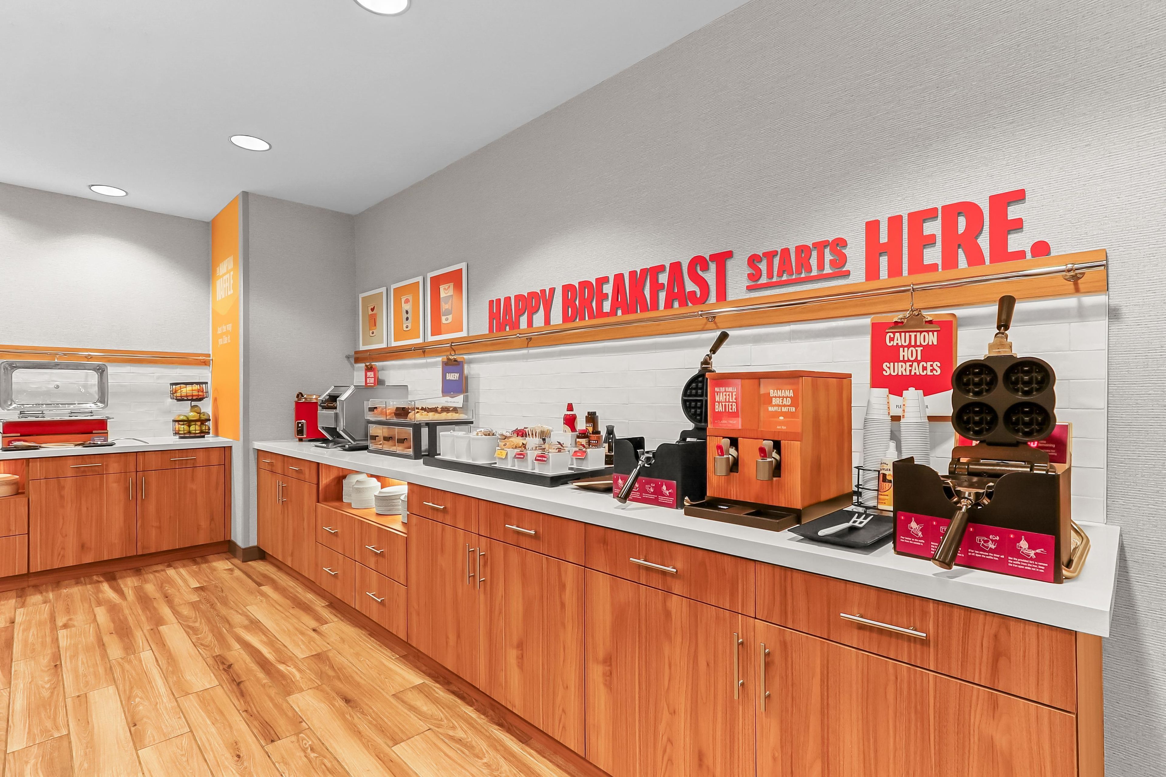 A breakfast area with a sign reading 'HAPPY BREAKFAST STARTS HERE.'