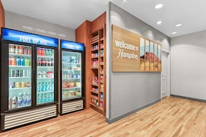 A hotel lobby with a 'Welcome to Hampton' sign, a 'Fuel Up Here' refrigerated display, and a 'Chill Out' refrigerated display. - Hampton Inn & Suites El Paso West (El Paso)