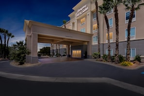 A hotel entrance with a covered walkway, palm trees, and a clear sky. - Hampton Inn & Suites El Paso West (El Paso)