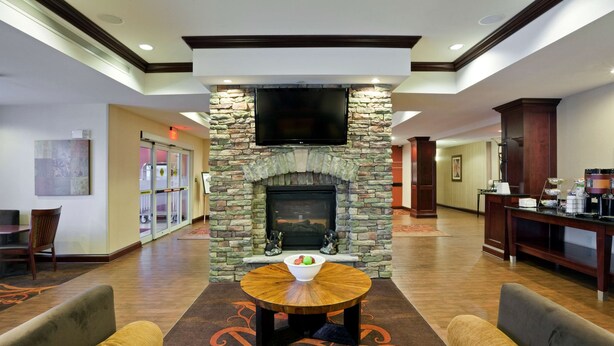 A spacious lobby with a stone fireplace, a flat-screen TV, and comfortable seating. - Hampton Inn Matamoras/Milford (Matamoras)