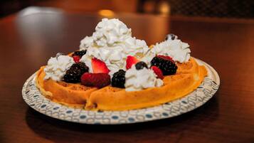 A waffle topped with whipped cream and fresh berries.