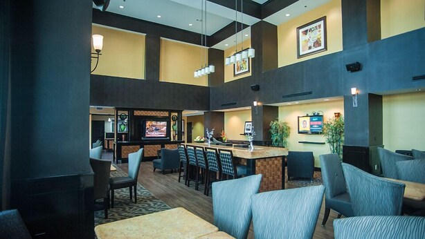 A spacious lobby with a central bar area, multiple seating options, and a modern design. - Hampton Inn & Suites Palestine (Palestine)