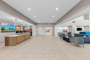 A spacious lobby with a reception desk, seating area, and a kitchenette. - Hampton Inn & Suites Palestine (Palestine)