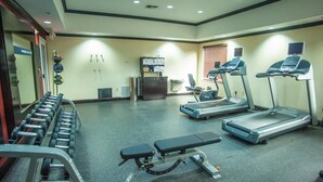A gym with treadmills, a bench, and dumbbells. - Hampton Inn & Suites Palestine (Palestine)