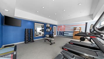 Ein modernes Fitnessstudio mit Laufbändern, Gewichten und Trainingsbällen.