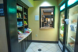 Ein Flur mit Snackregalen, einer kleinen Sitzecke und einer Kühlvitrine.