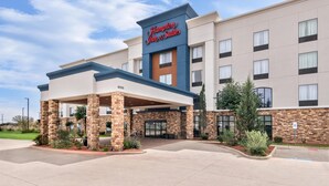 A Hampton Inn & Suites hotel with a covered entrance, brick facade, and a clear sky. - Hampton Inn and Suites Fort Worth/Forest Hill (Fort Worth)