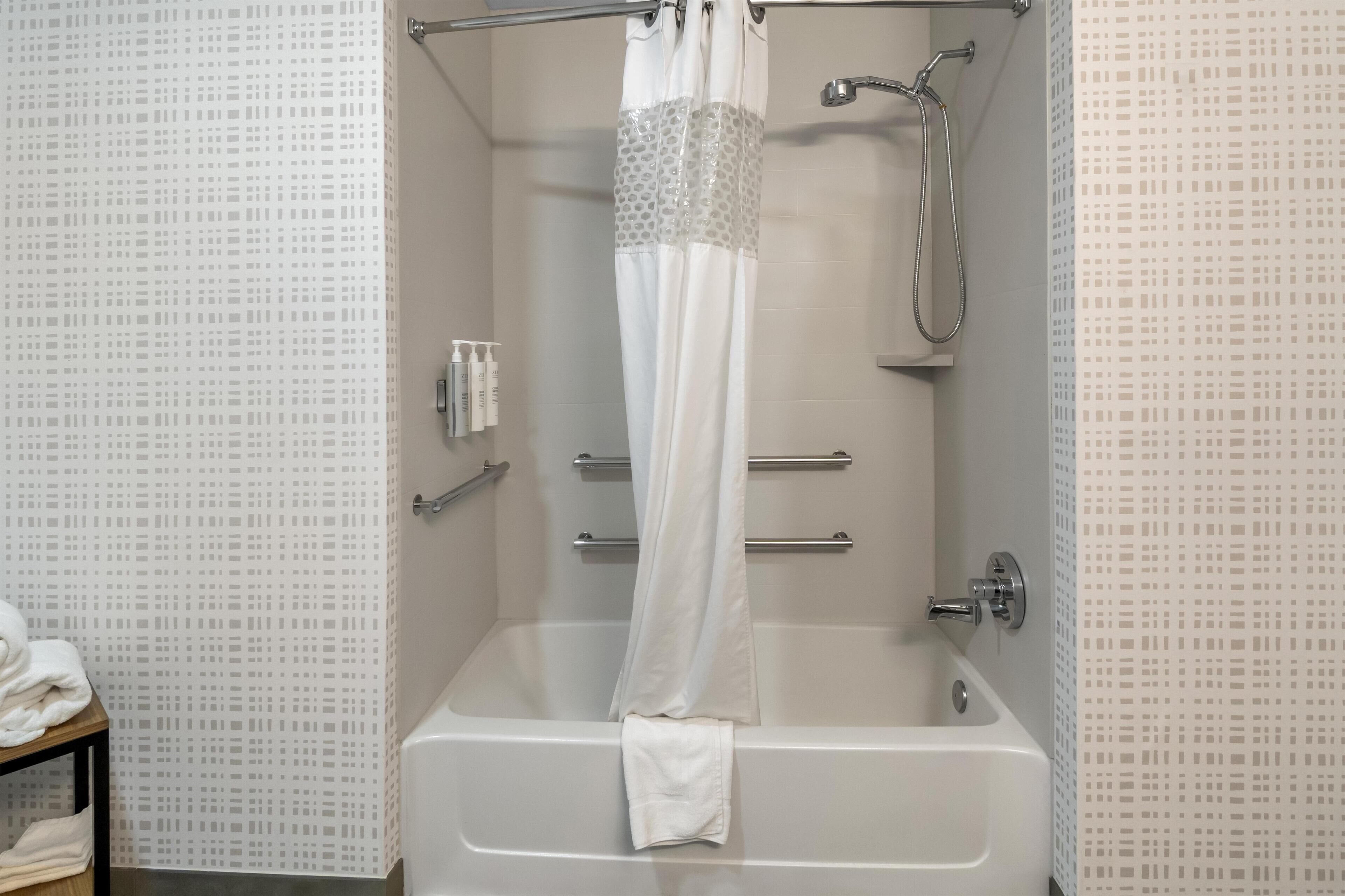 Un baño con bañera, ducha y toallero.