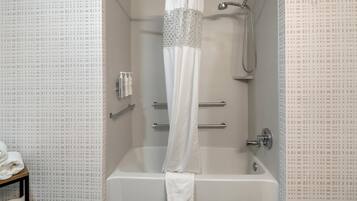 Un baño con bañera, ducha y toallero.