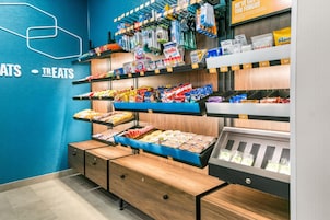 Zona de exhibición de aperitivos con diferentes productos envaselados y una sección refrigerada.