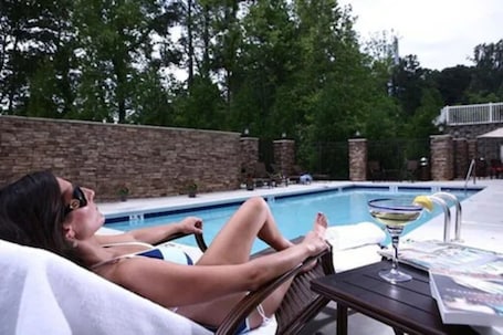 Una piscina al aire libre de temporada, sillones reclinables de piscina