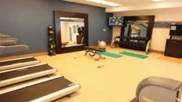 A gym with treadmills, exercise balls, and weights.