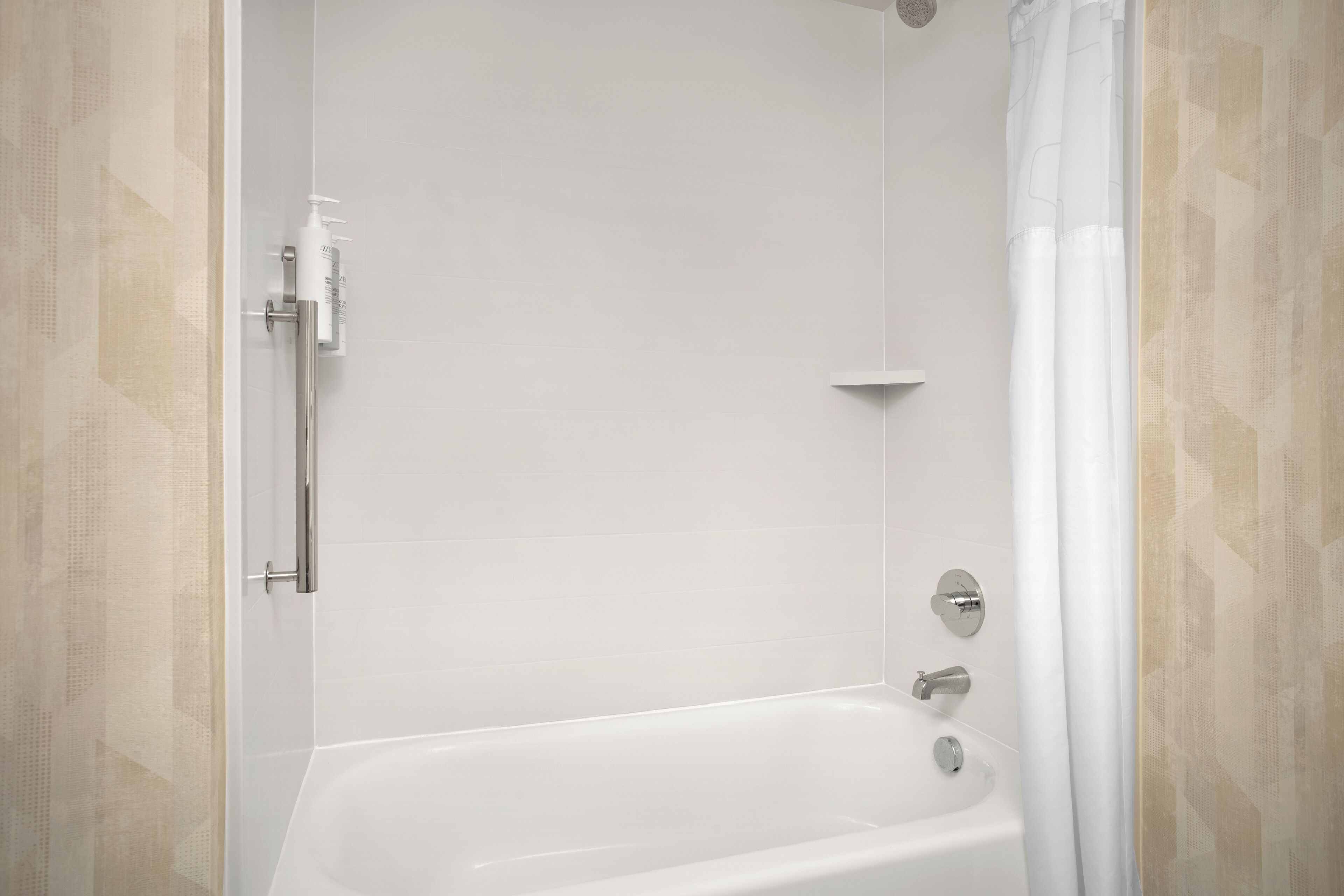 A modern bathroom with a bathtub, a showerhead, and a toilet.