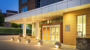 A modern hotel entrance with a covered walkway, stone bollards, and a sign indicating 'The Residences at 1101'. - Hotel Indigo Asheville Downtown by IHG (Asheville)