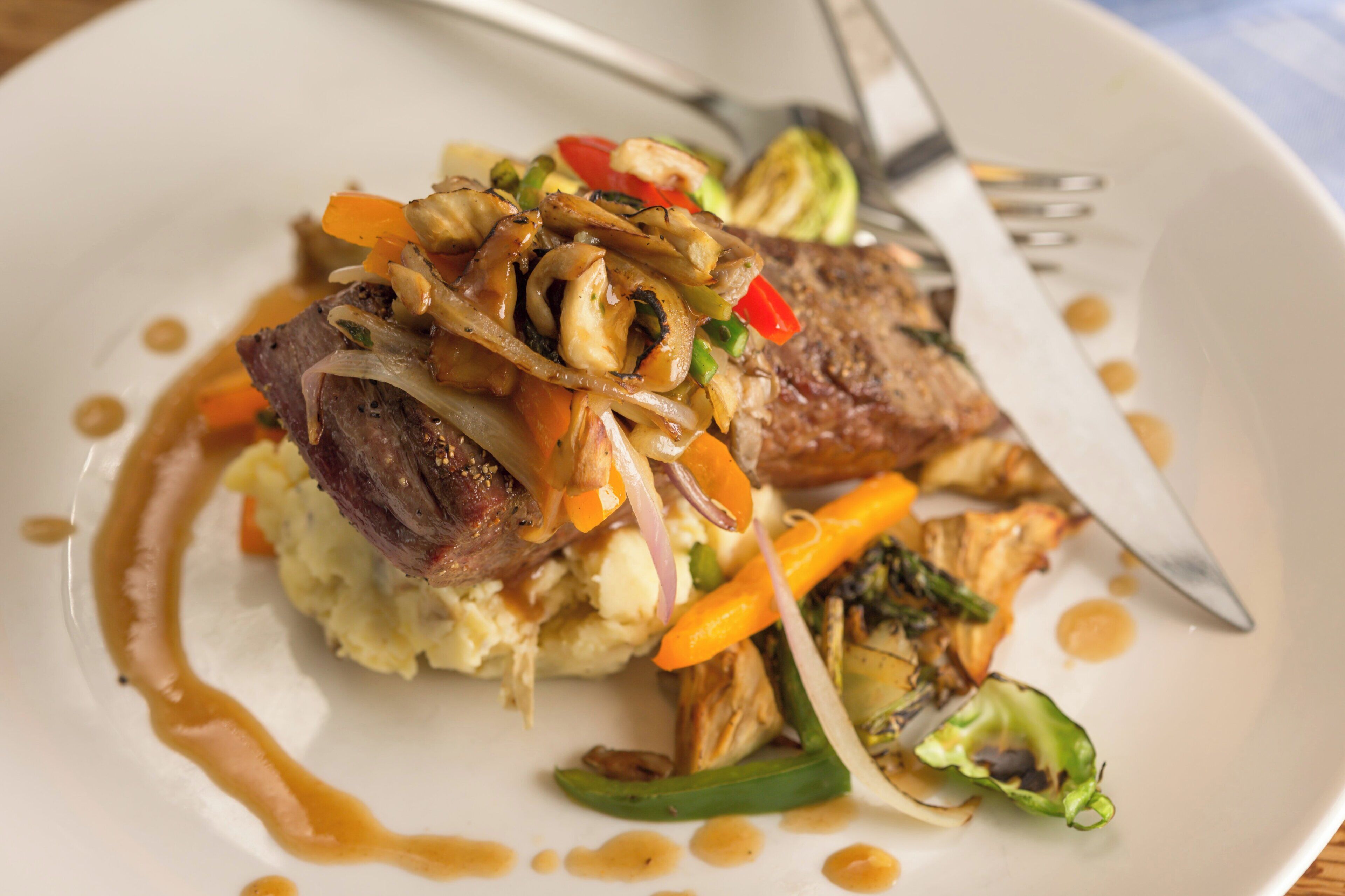 A plate with a steak, vegetables, and mashed potatoes.
