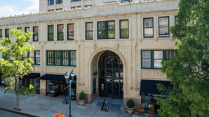 A historic building with a large arched entrance, multiple windows, and storefronts on the ground level. - Hotel Indigo Asheville Downtown by IHG (Asheville)