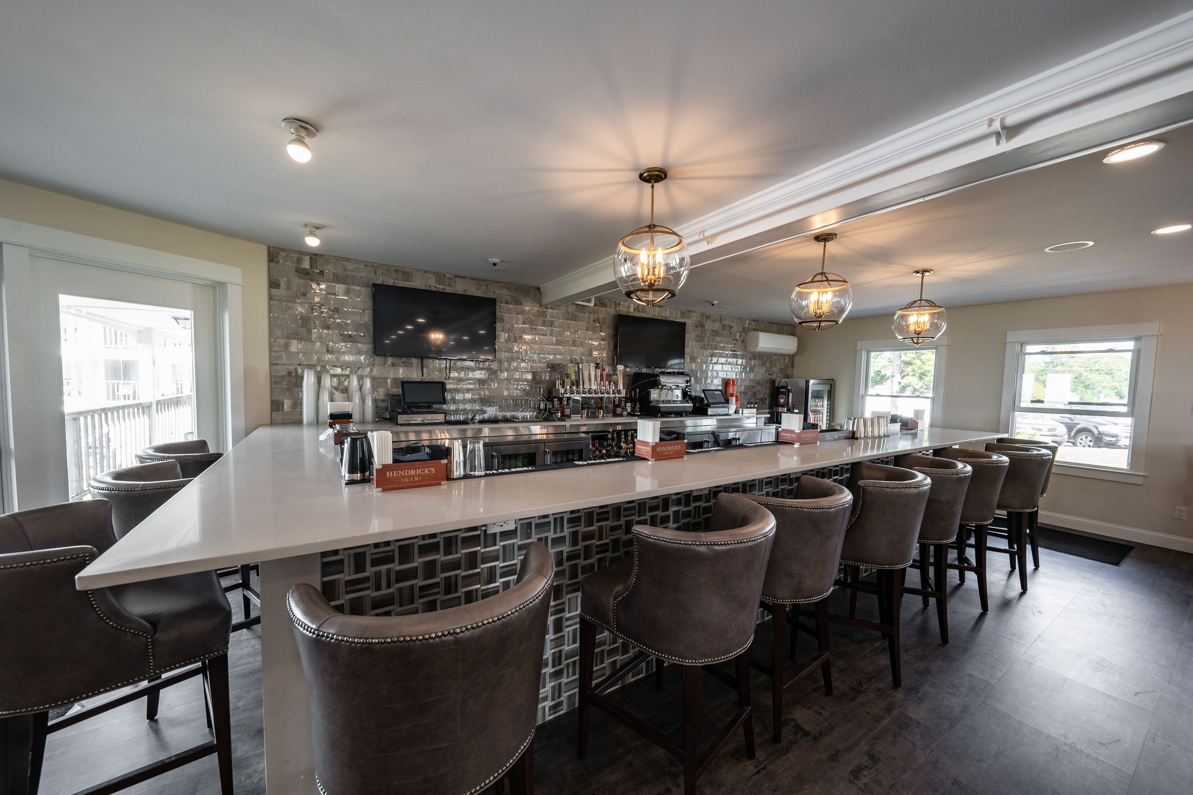 A modern kitchen with a central island, bar stools, and pendant lighting.