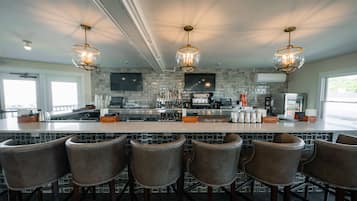 A modern kitchen with a central island, bar stools, and pendant lighting.
