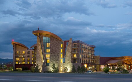 A modern hotel with a unique architectural design, featuring multiple levels and a prominent curved structure.