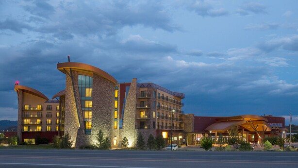 A modern hotel with a unique architectural design, featuring multiple levels and a prominent curved structure. - Sky Ute Casino Resort (Ignacio)