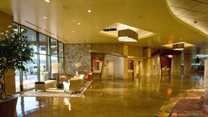 A spacious lobby with a polished floor, seating area, and a large potted plant. - Sky Ute Casino Resort (Ignacio)