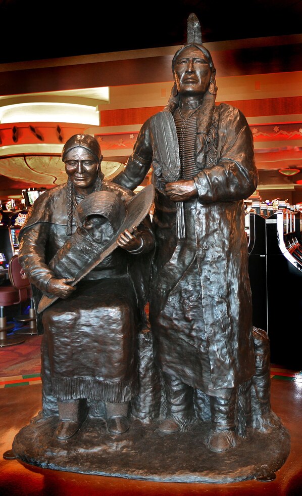 Una estatua de dos figuras con vestimenta tradicional, probablemente representando un significado histórico o cultural.