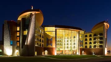 A modern hotel with a distinctive curved facade, large windows, and a central atrium.