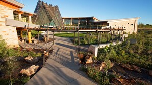 A modern building with a unique sloped roof and a pedestrian bridge connecting different sections. - Sky Ute Casino Resort (Ignacio)