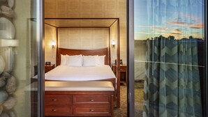 A hotel room with a large bed, a wooden dresser, and a view through a glass door. - Sky Ute Casino Resort (Ignacio)