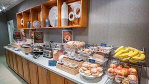 Un bufé de desayuno con diferentes opciones de comida y un letrero que dice 'Espinaca Fresca'.