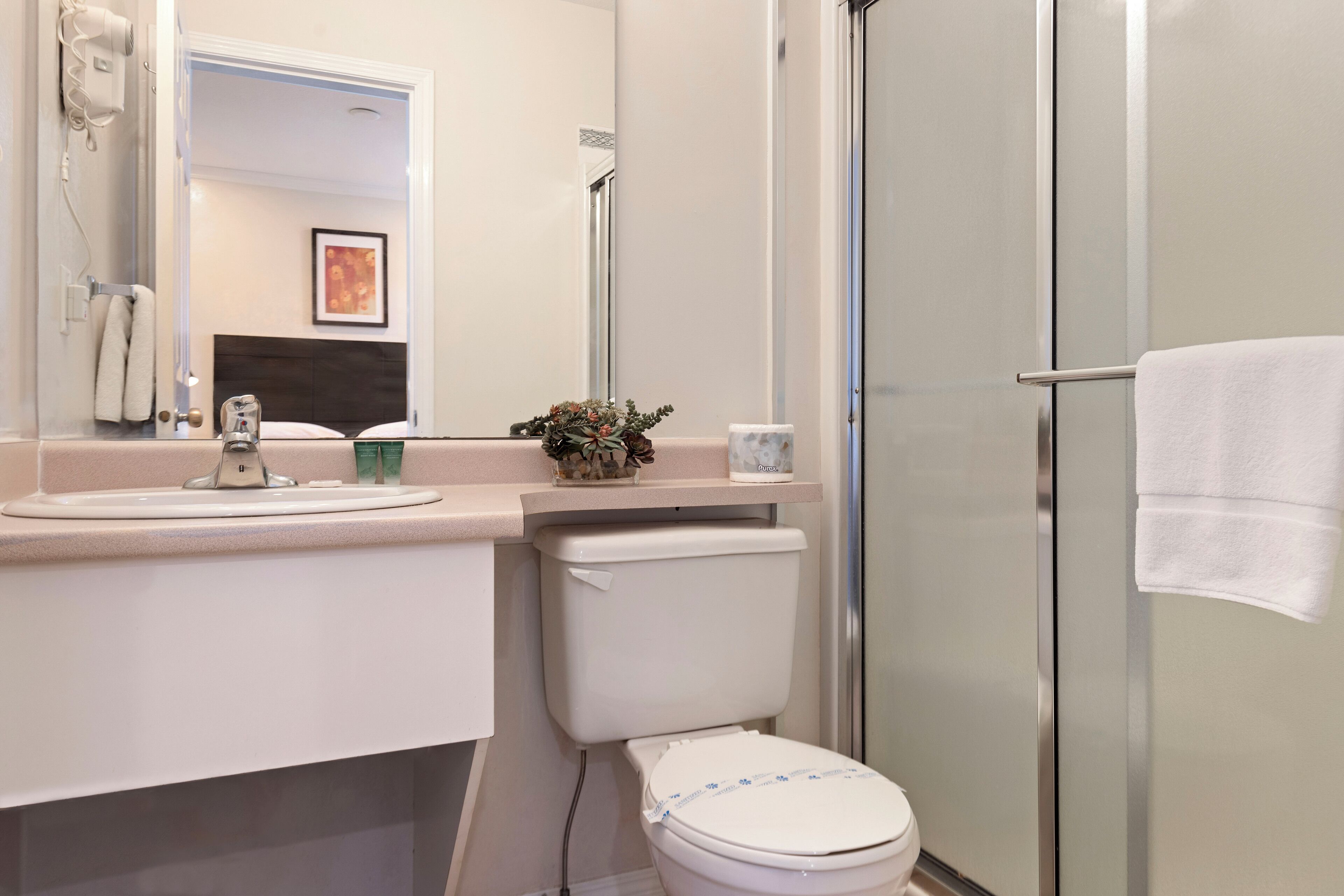A modern bathroom with a toilet, sink, and shower.