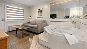 A modern bathroom with a bathtub, a mirror, and a toilet. - Oasis Inn (Kelowna)