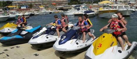 Jet skis docked at a marina with people on them.