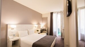 A hotel room with a large bed, bedside tables, a flat-screen TV, and a view of the outside. - Hôtel Cannes Croisette (Cannes)