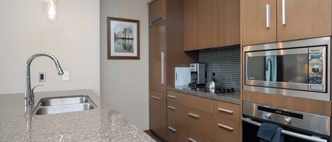A modern kitchen with granite countertops, stainless steel appliances, and wooden cabinets.