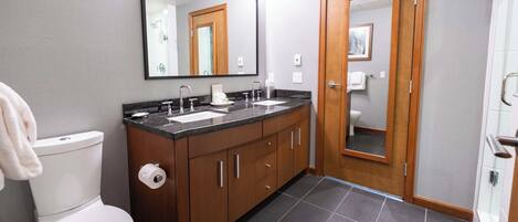 Un baño moderno con inodoro, lavamanos y espejo.