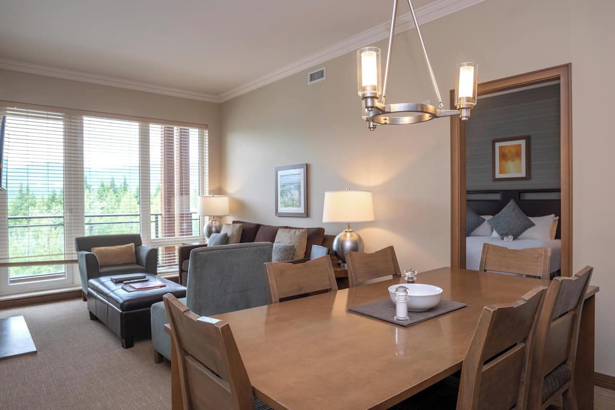Een hotelkamer met een eethoek, een bank en een bed.