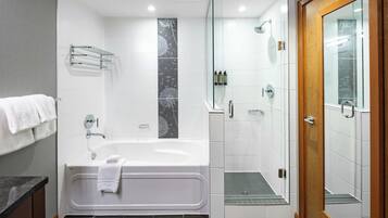 A modern bathroom with a bathtub, shower, and glass-enclosed shower stall.