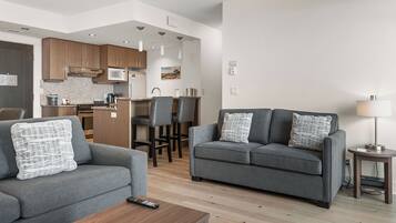 A modern living room with a grey sofa, a coffee table, and a lamp.