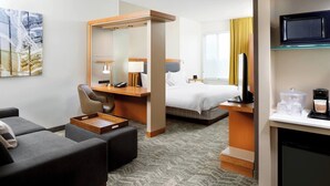 A hotel room with a bed, a desk with a computer, a chair, a sofa, and a television. - SpringHill Suites by Marriott Houston NASA/Webster (Webster)